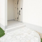 玄関ドア エレガントなアイアンの装飾とホワイトウッド。コントラストの利いた扉が華やかなエントランス空間を生み出しています。